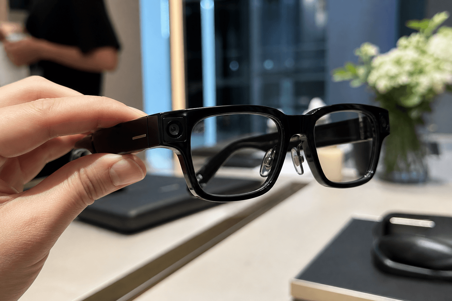 Czarne inteligentne okulary Huawei w nowoczesnym showroomie, sfotografowane jak okładkowy produkt technologiczny.